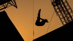 Eine Turmspringerin vor dem Abendhimmel. © imago/ Bildbyran