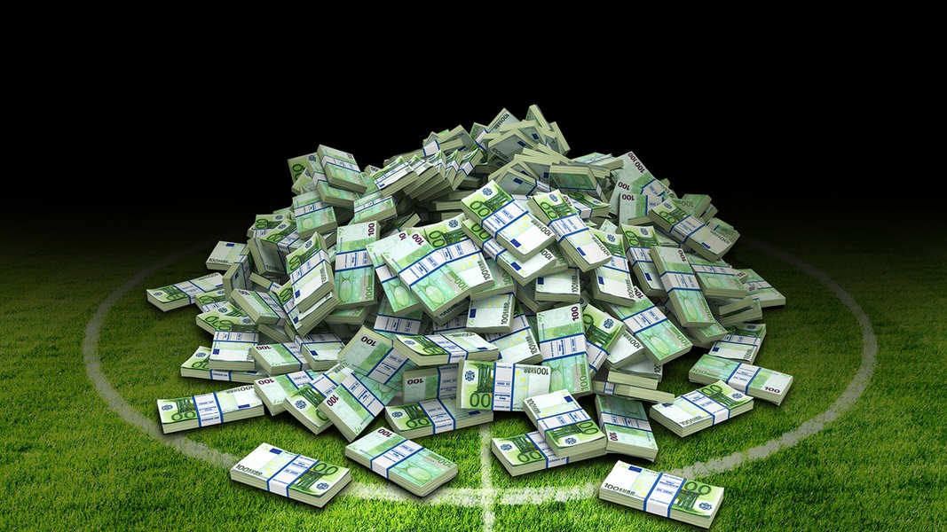 Geldbündel liegen auf einem Fußballplatz.