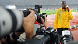 Sprint-Ass Usain Bolt präsentiert in Peking seine Goldmedaille © imago