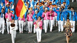 Natascha Keller trägt die deutsche Fahne bei der Eröffnung der Olympischen Spiele 2012. © picture alliance / dpa Foto: Jonathan Brady