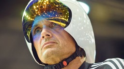 Der fünfmalige Paralympics-Sieger Michael Teuber schaut skeptisch. Im Visier seines Helms spiegelt sich die Berliner Radrennbahn.