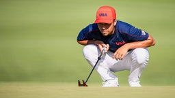 Der amerikanische Golfer Xander Schauffele in der Hocke. © IMAGO / Bildbyran 