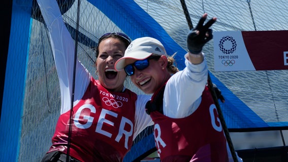 Susann Beucke (l.) und Tina Lutz bejubeln Segel-Silber bei den Olympischen Spielen in Tokio © picture alliance/dpa/Borgia 