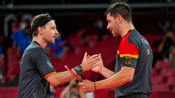 Die deutschen Tischtennis-Spieler Timo Boll (l.) und Patrick Franziska klatschen ab. © dpa-Bildfunk Foto: Vincent Thian/AP/dpa
