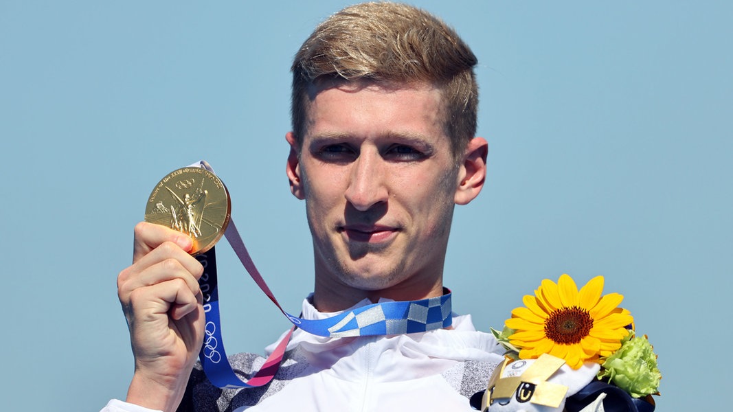 Der deutsche Schwimmer Florian Wellbrock präsentiert seine Goldmedaille im 10km Schwimmen.