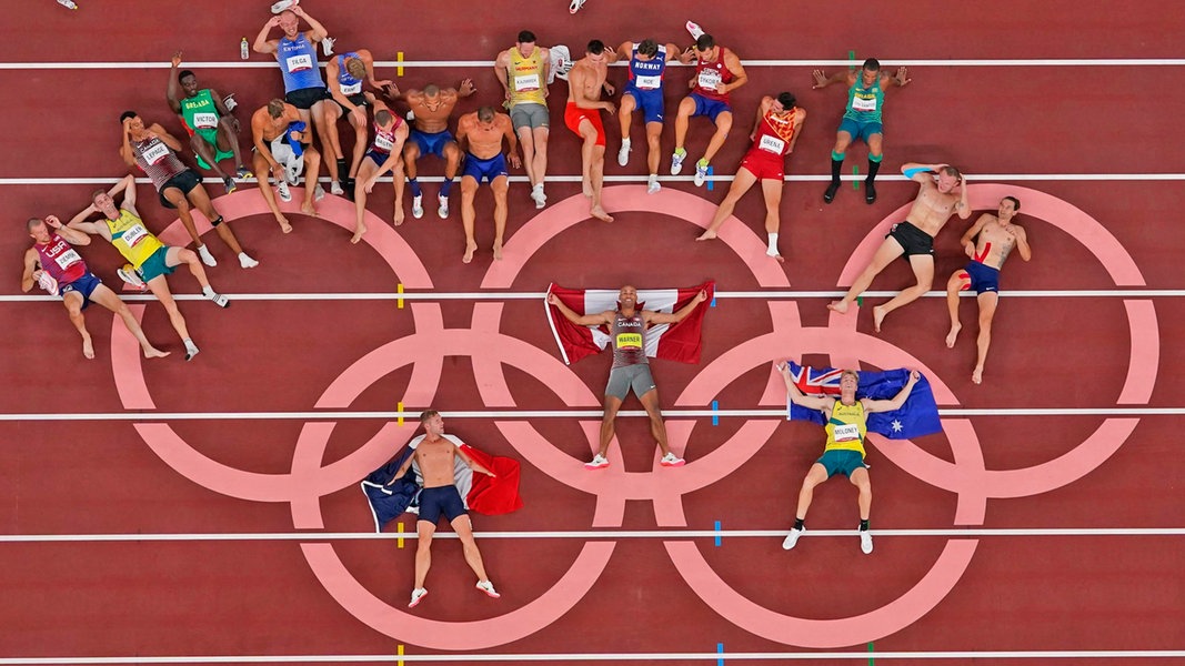 Die Athleten des Zehnkampfs posieren für ein Gruppen-Foto an den Olympischen Ringen.
