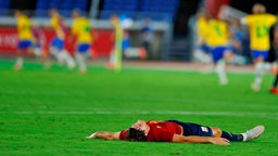 Spaniens Juan Miranda ist enttäuscht, während Brasiliens Spieler im Hintergrund jubeln. © IMAGO / Agencia EFE