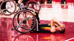 Der deutsche Rollstuhlbasketballer Thomas Böhme (M.) liegt enttäuscht auf dem Boden. © IMAGO / Beautiful Sports